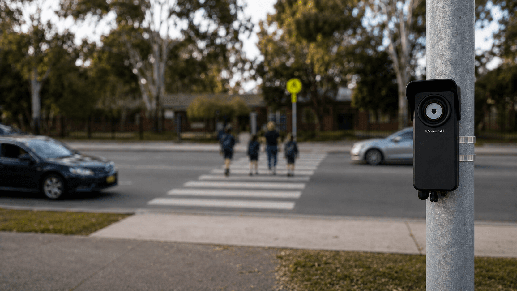 Xvision Scout roadside sensor mounted on an existing pole beside a school crossing as children cross the road.